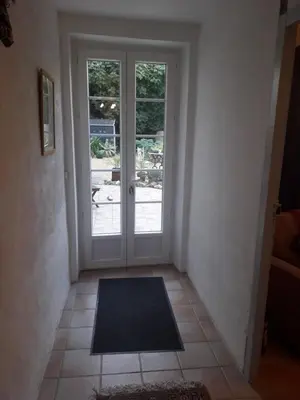 a hallway with a door with a mat in front of it at Maison Rose - Maison de village avec jardin privé, centre Capestang in Capestang