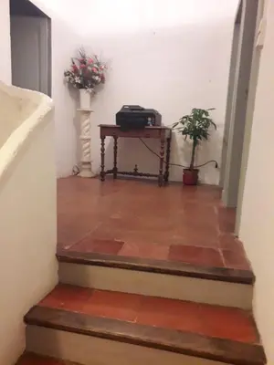 a stairway with a table with a suitcase on it at Maison Rose - Maison de village avec jardin privé, centre Capestang in Capestang