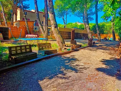 a park with benches and a table and trees at l'Entre Nous, jacuzzi privé et piscine à Carcassonne in Carcassonne