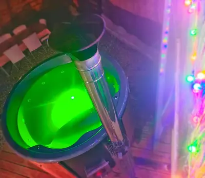 a green bowl in a vase with christmas lights at l'Entre Nous, jacuzzi privé et piscine à Carcassonne in Carcassonne