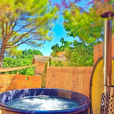 a large blue tub filled with water in a yard at l'Entre Nous, jacuzzi privé et piscine à Carcassonne in Carcassonne