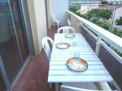 a white table with plates on it on a balcony at Appartement 3 pièces PORT LA NOUVELLE PN050-015 in Port-la-Nouvelle