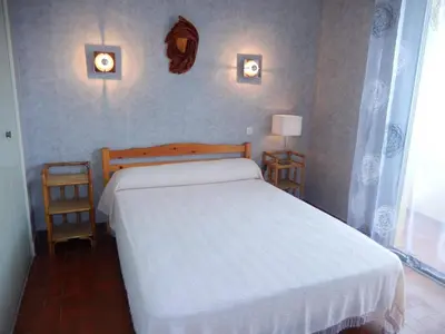 a bedroom with a white bed and two night stands at Appartement 3 pièces PORT LA NOUVELLE PN050-015 in Port-la-Nouvelle