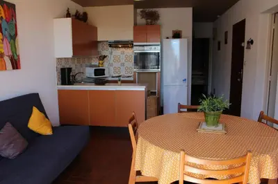 a kitchen and a table with a blue couch in a room at Appartement 3 pièces PORT LA NOUVELLE PN050-015 in Port-la-Nouvelle