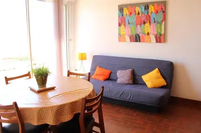 a living room with a blue couch and a table at Appartement 3 pièces PORT LA NOUVELLE PN050-015 in Port-la-Nouvelle