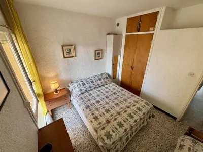 a small bedroom with a bed and a table at Appartement 2 pièces PORT LA NOUVELLE PN070-002 in Port-la-Nouvelle