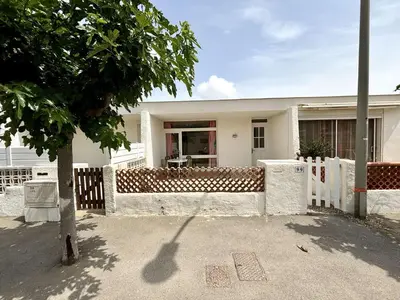 a white house with a fence in front of it at Maison 3 pièces PORT LA NOUVELLE PN080-006 in Port-la-Nouvelle