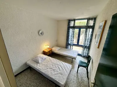 a small room with two beds and a window at Maison 3 pièces PORT LA NOUVELLE PN080-006 in Port-la-Nouvelle