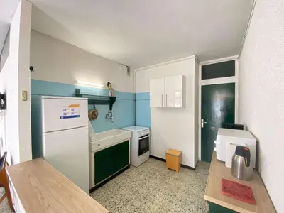 a small kitchen with a refrigerator and a sink at Maison 3 pièces PORT LA NOUVELLE PN080-006 in Port-la-Nouvelle