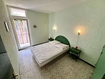 a small bedroom with a bed and a window at Maison 3 pièces PORT LA NOUVELLE PN080-006 in Port-la-Nouvelle