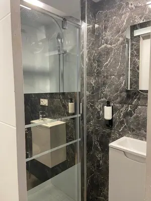a bathroom with a glass shower with a sink at Chambres chez l'habitant in Salles-d'Aude