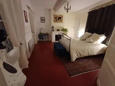 a bedroom with a bed and a desk in it at Appartement vue panoramique in Carcassonne