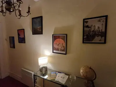 a room with a lamp and pictures on the wall at Appartement vue panoramique in Carcassonne