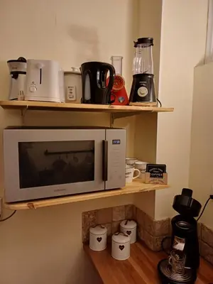 a microwave on a shelf in a kitchen at Appartement vue panoramique in Carcassonne