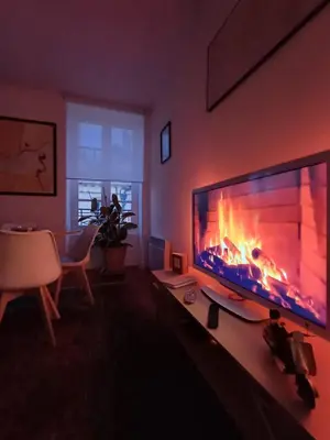 a living room with a large television with a fireplace at Appartement vue panoramique in Carcassonne