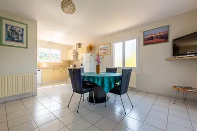 a kitchen and dining room with a table and chairs at Gîte L'Orée du Lac in Carcassonne