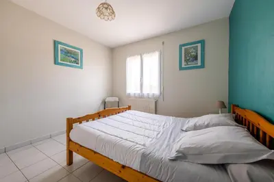 a bedroom with a large bed with blue walls at Gîte L'Orée du Lac in Carcassonne