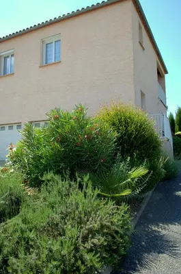 a building with bushes in front of a building at Gîte L'Orée du Lac in Carcassonne
