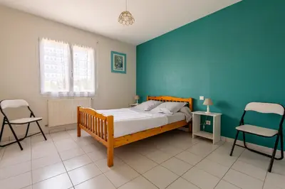 a bedroom with a bed and two chairs in it at Gîte L'Orée du Lac in Carcassonne