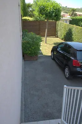 a black car is parked in a driveway at Gîte L'Orée du Lac in Carcassonne