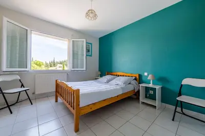 a bedroom with a bed and a blue wall at Gîte L'Orée du Lac in Carcassonne