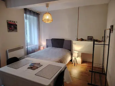 a bedroom with a bed with a table and a lamp at Le Coeur de Négrin in Mazamet