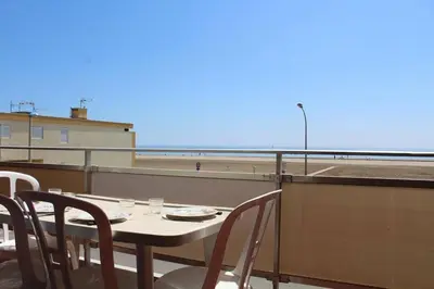 a table and chairs on a balcony with a view of the beach at Appartement 2 pièces PORT LA NOUVELLE PN210-036 in Port-la-Nouvelle