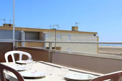 a table on a balcony with a view of the beach at Appartement 2 pièces PORT LA NOUVELLE PN210-036 in Port-la-Nouvelle