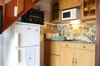 a kitchen with a white refrigerator and a microwave at Appartement Studio mezzanine PORT LA NOUVELLE PN290-103 in Port-la-Nouvelle