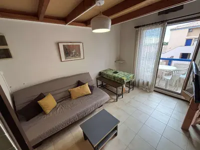 a living room with a couch and a table at Appartement Studio mezzanine PORT LA NOUVELLE PN290-103 in Port-la-Nouvelle
