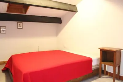 a bedroom with a red bed and a wooden table at Appartement Studio mezzanine PORT LA NOUVELLE PN290-103 in Port-la-Nouvelle