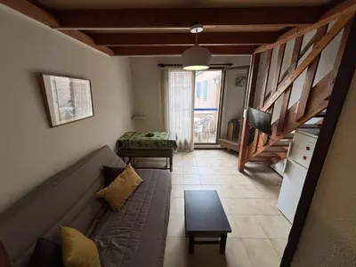 a living room with a couch and a tv at Appartement Studio mezzanine PORT LA NOUVELLE PN290-103 in Port-la-Nouvelle
