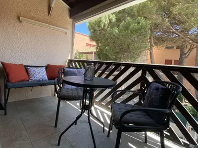 a patio with a table and chairs on a balcony at Appartement studio Mezzanine Port la Nouvelle PN340-010 in Port-la-Nouvelle