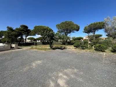 an empty parking lot with trees in the background at Appartement studio Mezzanine Port la Nouvelle PN340-010 in Port-la-Nouvelle