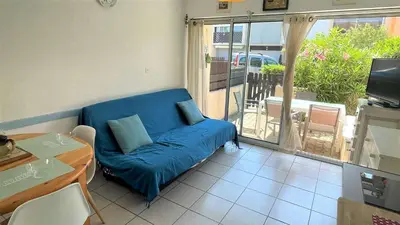 a blue couch in a living room with a balcony at APPARTEMENT 3 pieces PORT LA NOUVELLE PN340-126 in Port-la-Nouvelle