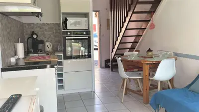 a kitchen and dining room with a table and a staircase at APPARTEMENT 3 pieces PORT LA NOUVELLE PN340-126 in Port-la-Nouvelle