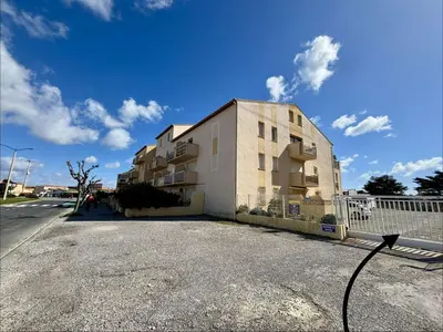 a white house with a tree in front of it at Maison 3 pièces mezzanine PORT LA NOUVELLE PN360-013 in Port-la-Nouvelle