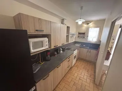 a kitchen with wooden cabinets and a microwave at Maison 3 pièces mezzanine PORT LA NOUVELLE PN360-013 in Port-la-Nouvelle