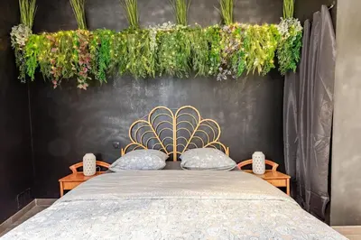 a bedroom with a bed with plants above it at Cocon Bohème Proche Gare in Narbonne