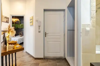 a white door in a hallway with a bedroom at Cocon Bohème Proche Gare in Narbonne