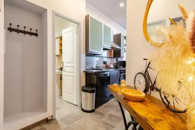 a kitchen with a wooden table and a counter top at Cocon Bohème Proche Gare in Narbonne