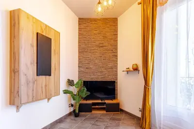 a living room with a television and a brick wall at Cocon Bohème Proche Gare in Narbonne