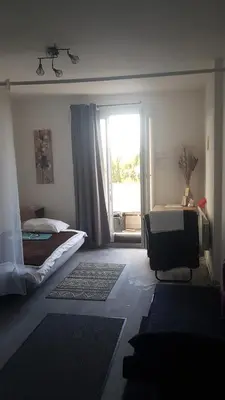 a bedroom with a bed and a large window at Les Vergers in Narbonne