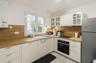 a kitchen with white cabinets and white appliances at Chez Maxou - 3 ēpis Jardin Clos-Garage-Dogfriendly in Revel