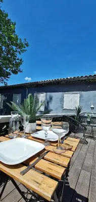 a wooden table with wine glasses on a deck at N1-Terrasse - Barbacane - Pieds Cité - Clime Mobile in Carcassonne