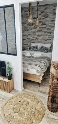 a bedroom with a bed with a brick wall at N1-Terrasse - Barbacane - Pieds Cité - Clime Mobile in Carcassonne