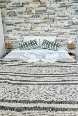 a bedroom with a large bed with a brick wall at N1-Terrasse - Barbacane - Pieds Cité - Clime Mobile in Carcassonne