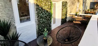 a porch with two chairs and a table with a plant at N1-Terrasse - Barbacane - Pieds Cité - Clime Mobile in Carcassonne
