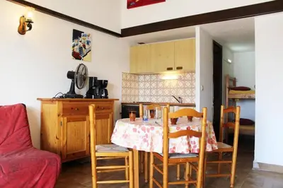 a kitchen with a table and chairs in a room at Maison deux pièces cabine PORT LA NOUVELLE PN370-026 in Port-la-Nouvelle