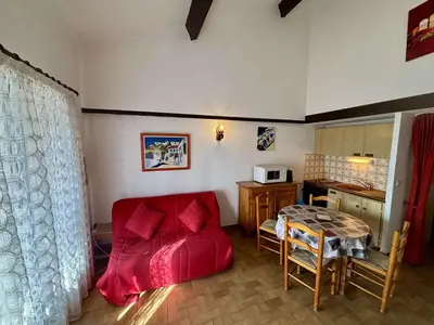 a living room with a red couch and a table at Maison deux pièces cabine PORT LA NOUVELLE PN370-026 in Port-la-Nouvelle